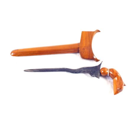 A kris with carved wooden grip within its hardwood scabbard