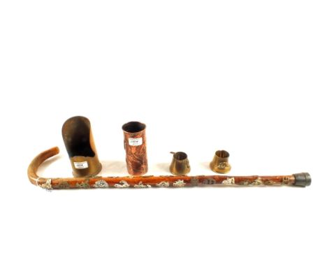 A collection of Trench Art and walking stick embellished with military badges