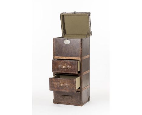 Commode en cuir fauve à trois tiroirs en partie basse séparés par des traverses en bois cloutés et un coffre en partie haute.