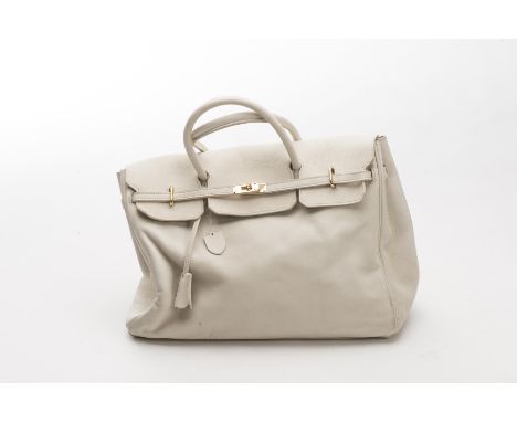 Charles Jourdan Paris, sac cabas à rabat en cuir de taureau couleur ficelle et fermeture dorée.Porté épaule ou main.H. 31x42 