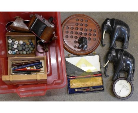A Bakelite thermometer, carved elephants, a solitaire game, pens, Kodak Retina camera, etc.