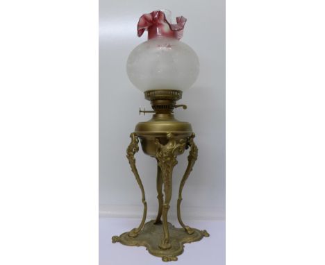 An oil lamp with a gilt metal base, 64cm
