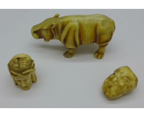 A carved figure of a stylised hippopotamus, a/f, an ivory figure of Jesus Christ/Skeleton head and one other item, (3)