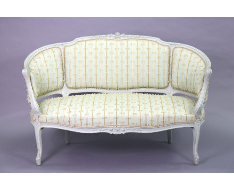 A French Louis XV-style sofa with carved decoration to the painted frame, upholstered striped material with decorative tassel