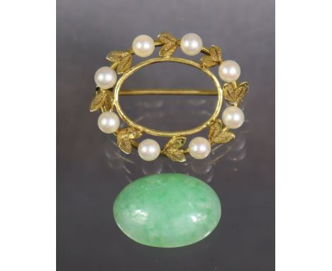 A 9ct. gold oval brooch set pale green jade within a border of cultured pearls; 2.5 cm wide. (5.5 gm).