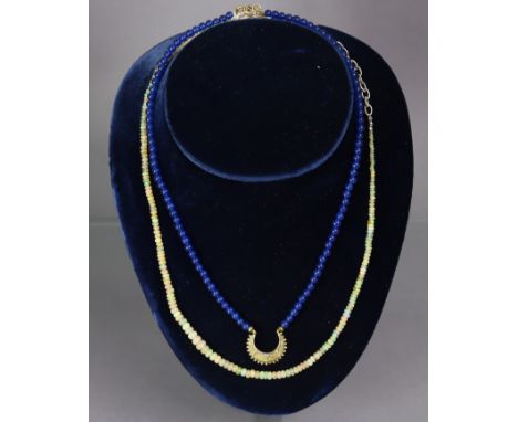 A necklace of graduated opal beads, 50 cm long; &amp; a necklace of near-uniform sapphire beads, with gilt-metal crescent sha