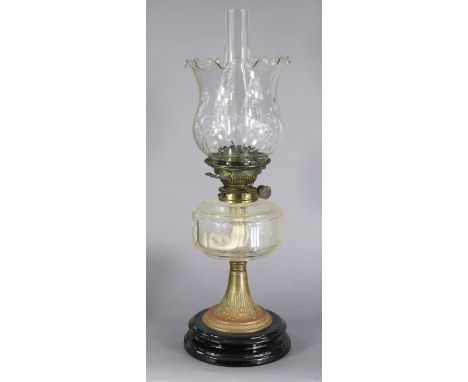 A Victorian brass oil lamp with cut-glass shade &amp; faceted reservoir, on black-glazed ceramic circular base, 22¼” high.