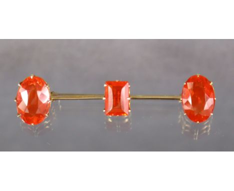 A FIRE OPAL KNIFE-EDGE BAR BROOCH, the rectangular-cut centre stone approx. 10mm x 7mm x 4mm, an oval-cut stone either end, a