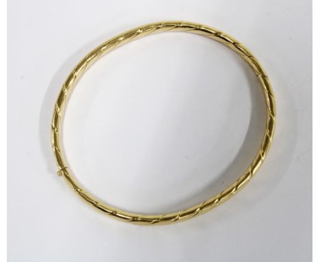 18ct gold bangle with incised design, stamped 750