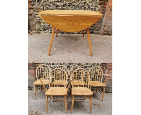 A mid century blonde elm circular drop leaf table together with a set of six Ercol windsor dining chairs, comprising four cha