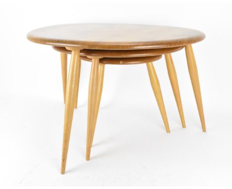 A nest of three Ercol blonde elm pebble tables, model 354, each raised on three turned splayed legs, the tallest 40 cm high x