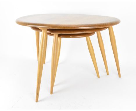 A nest of three Ercol blonde elm pebble tables, model 354, each raised on three turned splayed legs, the tallest 40 cm high x