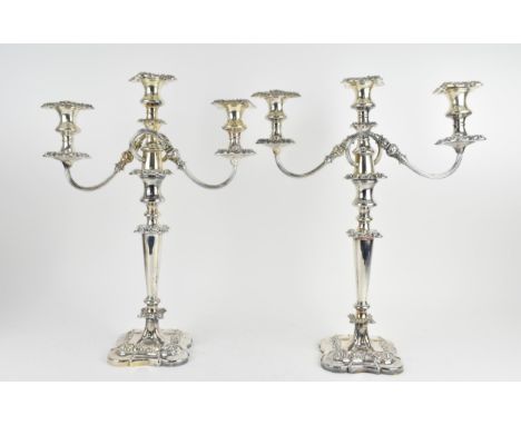 A near pair of silver-plated three-light candelabra, in the Georgian style with scrolled arms, the top section removable to h