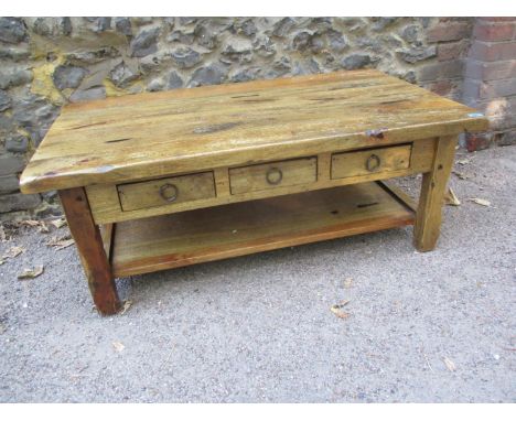 A mango wood coffee table with three small drawers and shelf below 