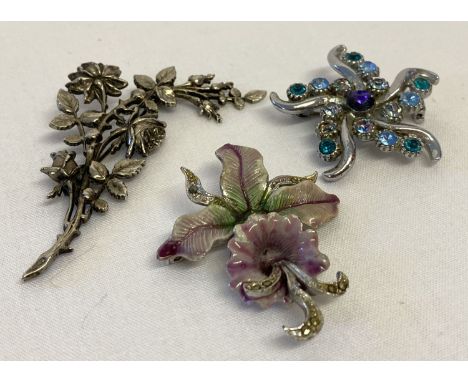 3 floral design vintage costume jewellery brooches.  A silver tone floral spray, a flower design set with coloured stones (on