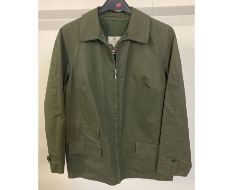 A ladies vintage golfer jacket in khaki green terylene by Grenfell.  Zip front with front pockets and waist adjust side butto