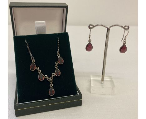 A vintage silver necklace with 5 teardrop cut garnets.  Together with a pair of silver drop earrings set with teardrop cut ca
