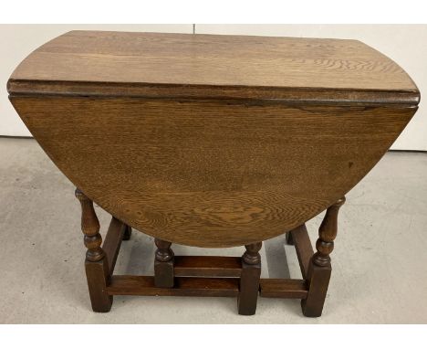 A small solid oak drop leaf gate leg coffee table.   Approx 59cm x 48cm tall.