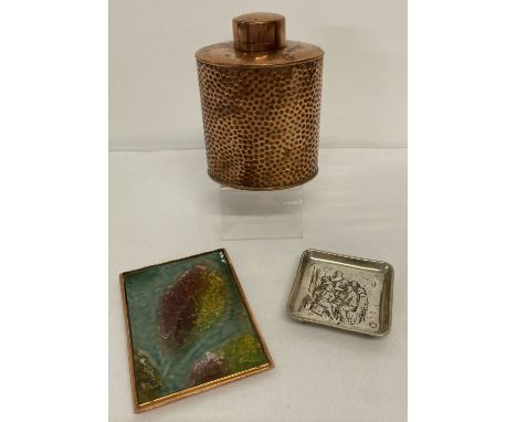 A vintage copper tea caddy with hammered effect decoration.  Together with a small enamel and copper plaque and a white metal