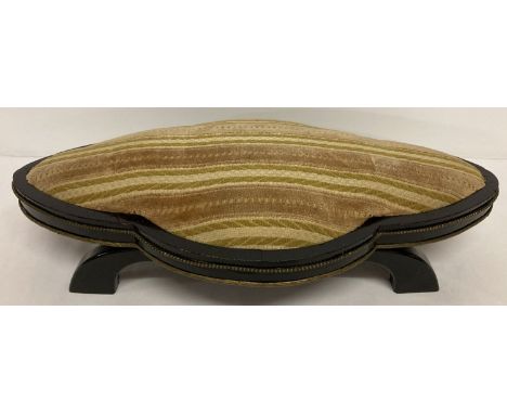 A vintage wooden low footstool with brass engraved and beaded trim.  Painted black with striped material in natural tones.  A