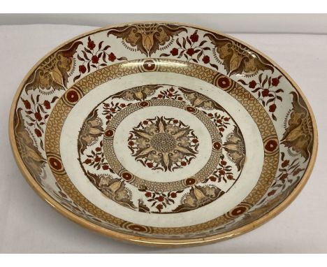 A large Dutch ceramic charger with floral decoration and lustre detail. Etched initials to side.  Stamped Petrus Regout &amp;