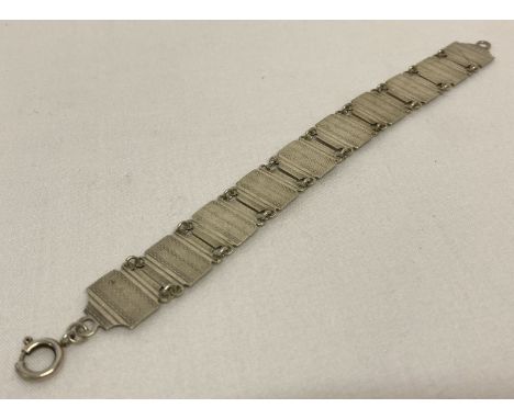 An Art Deco silver link bracelet with engine turned detail.  Stamped 'silver' to reverse.  Approx. 7.5" long.