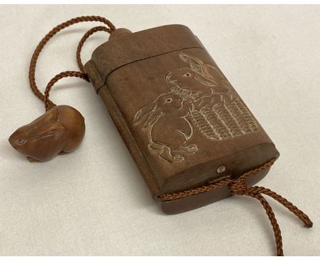 A Chinese carved hardwood Inro; stacking snuff/spice box.  With rabbits in a basket detail to each side and carved rabbit sha