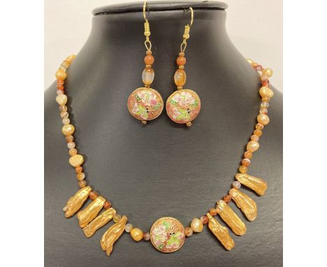 A boxed 15" carnelian and peach freshwater pearl necklace with central 2 sided enamelled bead.  Together with a pair of match
