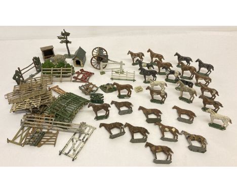 A collection of vintage lead horse figures together with a quantity of fences, huts, hedges etc.  