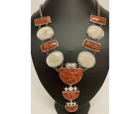 A large white metal statement necklace set with mother of pearl, keshi pearl and red stones.  With lobster claw clasp and siz