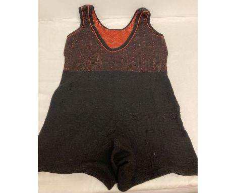 A 1920's knitted blue and red swimming costume with age related wear.  Button fastenings to shoulders.  Chest approx. 38 inch