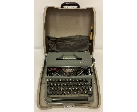 A vintage Olympia typewriter complete with protective cover, cleaning brush and carry case.  