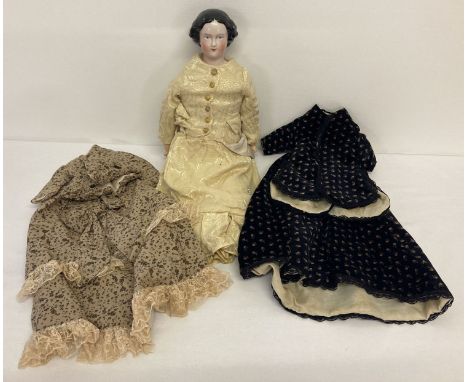 A vintage doll with ceramic head and feet, straw filled cloth body and composite hands. Dressed in handmade silk lined period