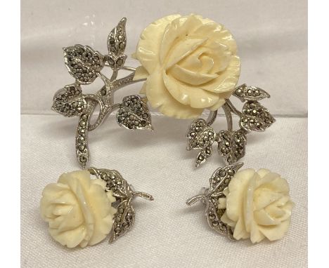 A vintage matching brooch and clip on earrings with carved rose detail and set with marcasites.   Brooch approx. 5cm wide.