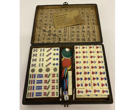 A cased Chinese Mah Jong set complete with instructions, counters dice and blank tiles.  3 sets of playing tiles still sealed