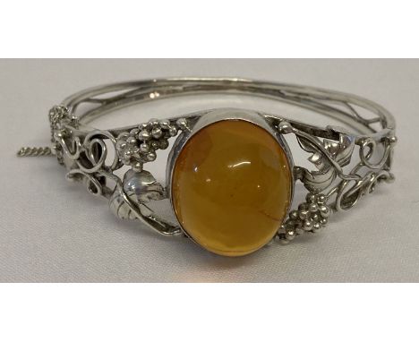A Polish silver decorative bangle set with central Baltic amber cabochon with push clasp.  Complete with safety chain. Grape 