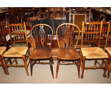 A set of four elm rush seated spindle back dining chairs and a pair of elm seated stick and wheel back chairs 