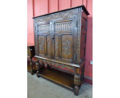 A 17th Century style carved oak cupboard on stand, by G.T. Rackstraw, Worcester