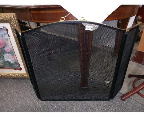A modern brass and mesh fire screen.