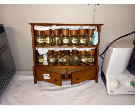A hanging wooden spice rack with jars