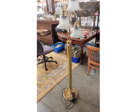 A brass floor lamp with 3 bulbs