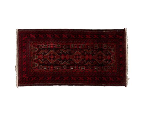 Persian Wool Rug  Baluch style geometric abstract rug in hues of orange, red, white and green on a field of black, having fri