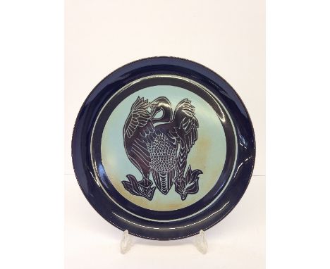 A Poole Pottery Aegean dish, decorated with a stylised bird in tones of brown on duck egg blue ground by Alan Clarke, impress