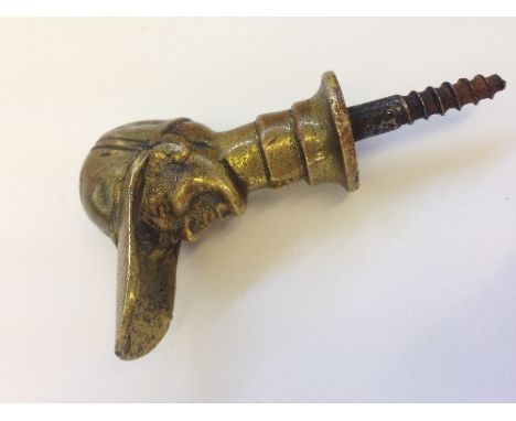 A novelty brass walking stick handle modelled as a Jockey wearing a long peaked cap.