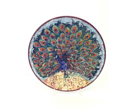 A Poole Pottery Living Glaze charger by Tony Morris, decorated with a Peacock displaying its feathers in tones of orange, red