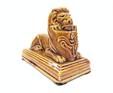 A Poole Pottery Carter Stabler Adams brown glazed stoneware advertising paperweight modelled as a 'lion restant' with shield 