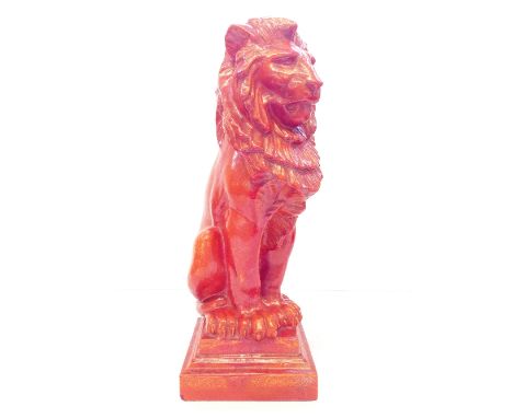 A large Poole Pottery Carter and Co. orange uranium glazed model of a seated lion (lion sejant) after a design by Alfred Stev