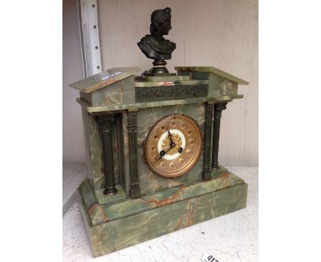 An early 20th century architectural onyx and brass mounted mantle clock with classical male bust finial.