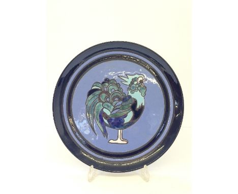 A Poole Pottery Ionian dish, decorated with an image of a Cockerel in tones of blue, green and black, painted by J. Mackenzie