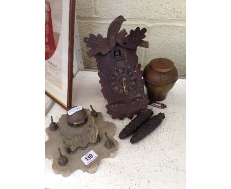 A late 19th century glass inkwell on alabaster stand together with a cuckoo clock and an Empire Exhibition brass tea caddy.